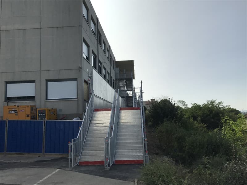 Escalier d'accès provisoire avec garde-corps installé devant un collège